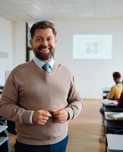 Happy university teacher in the classroom looking at camera. Happy university teacher in the classroom looking at camera.
